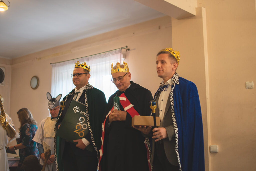 Scena z jasełek. Trzej Królowie Burmistrz, Ksiądz Proboszcz oraz Karol Bruzda stoją przybyli do Dzieciątka Jezus.